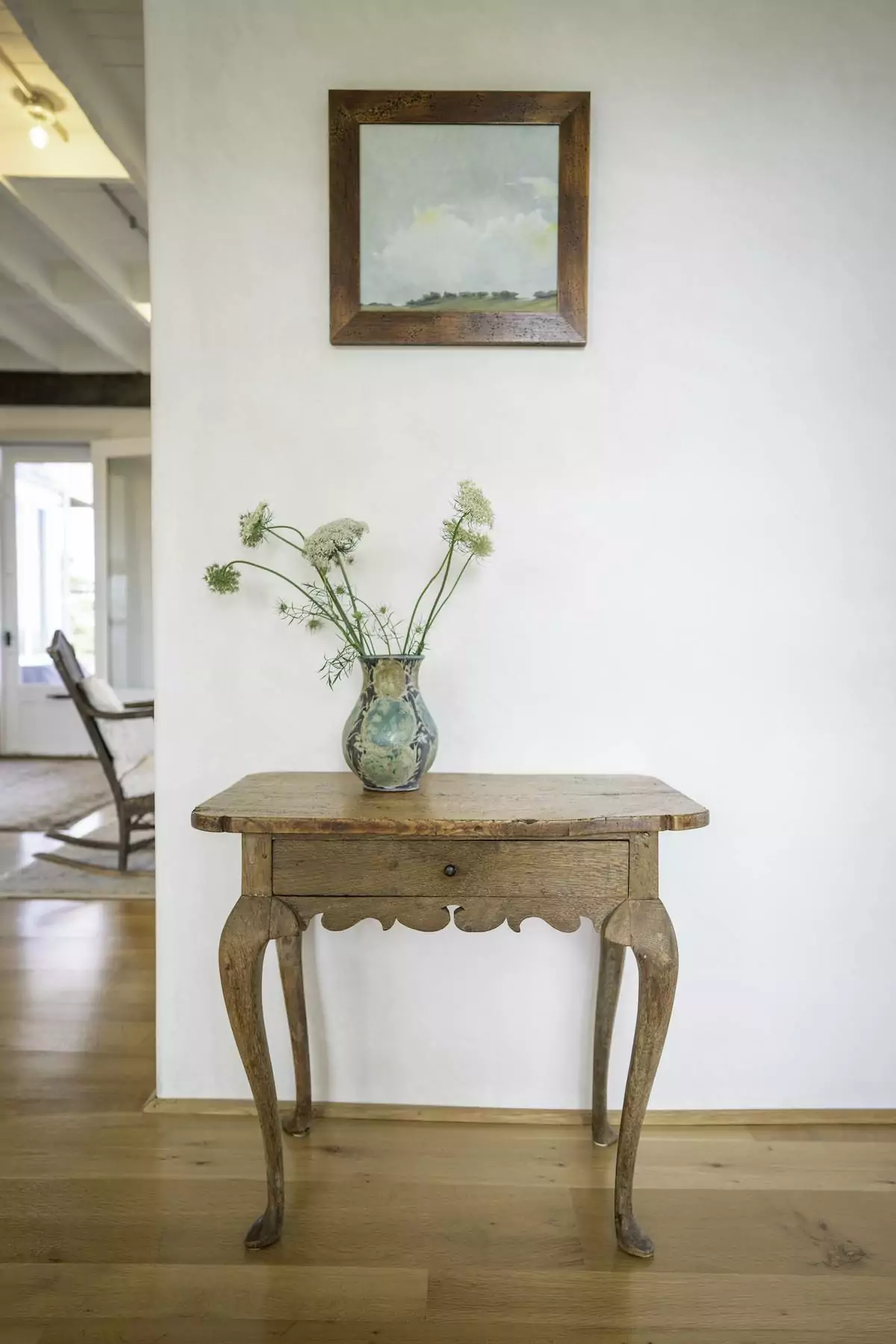 A wooden side table with vase