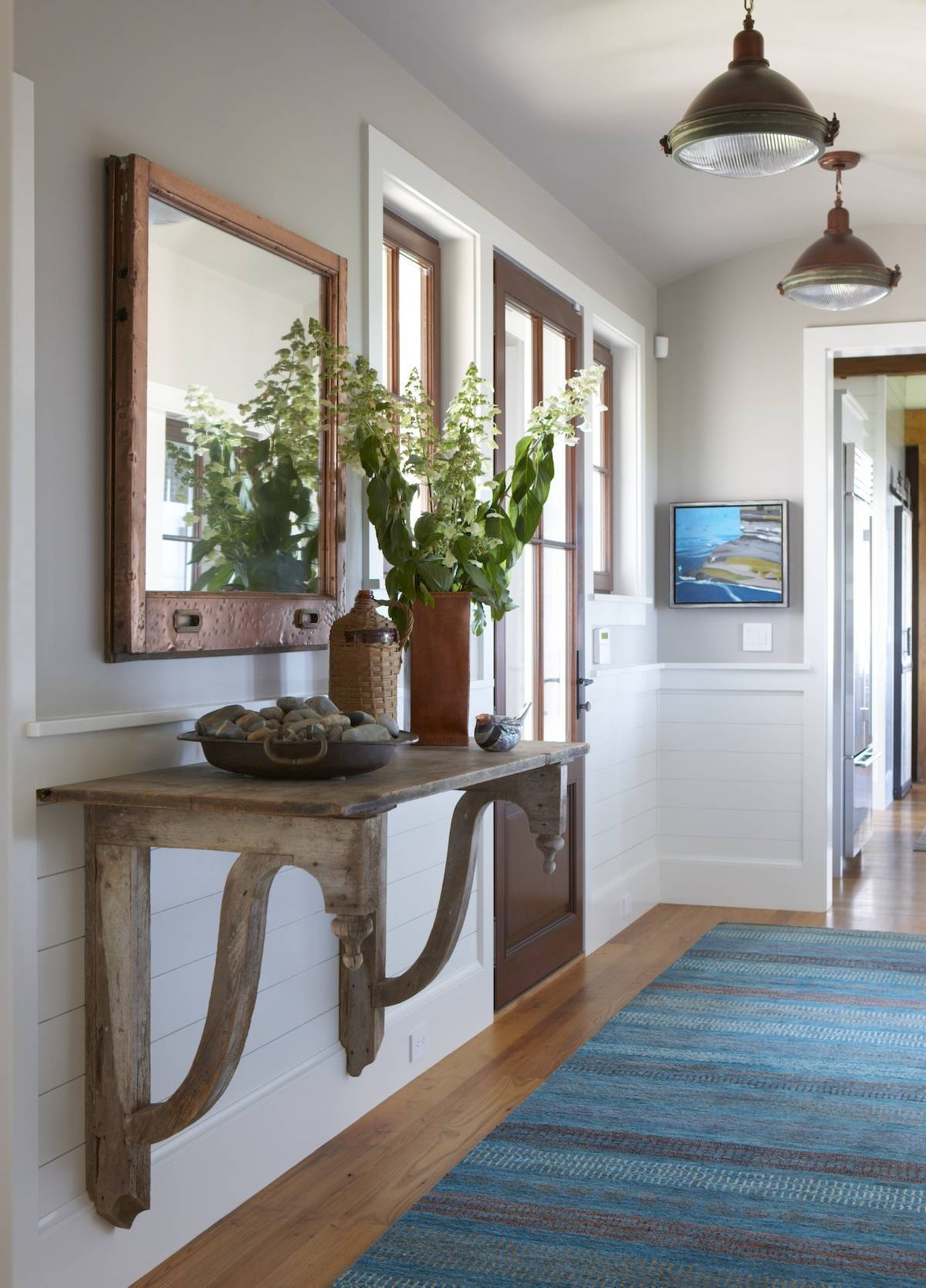 Area rugs in front of an accent table in an entryway