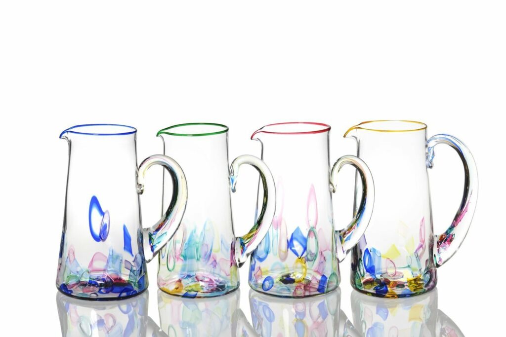 four blown glass pitchers in various colors