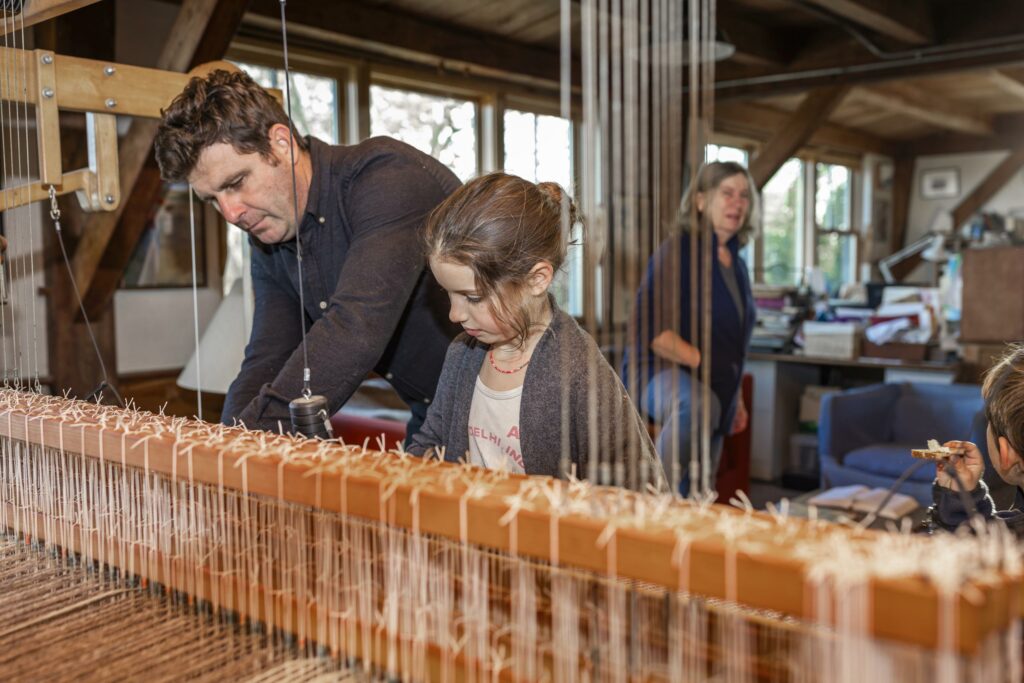 man and child at weaving loom