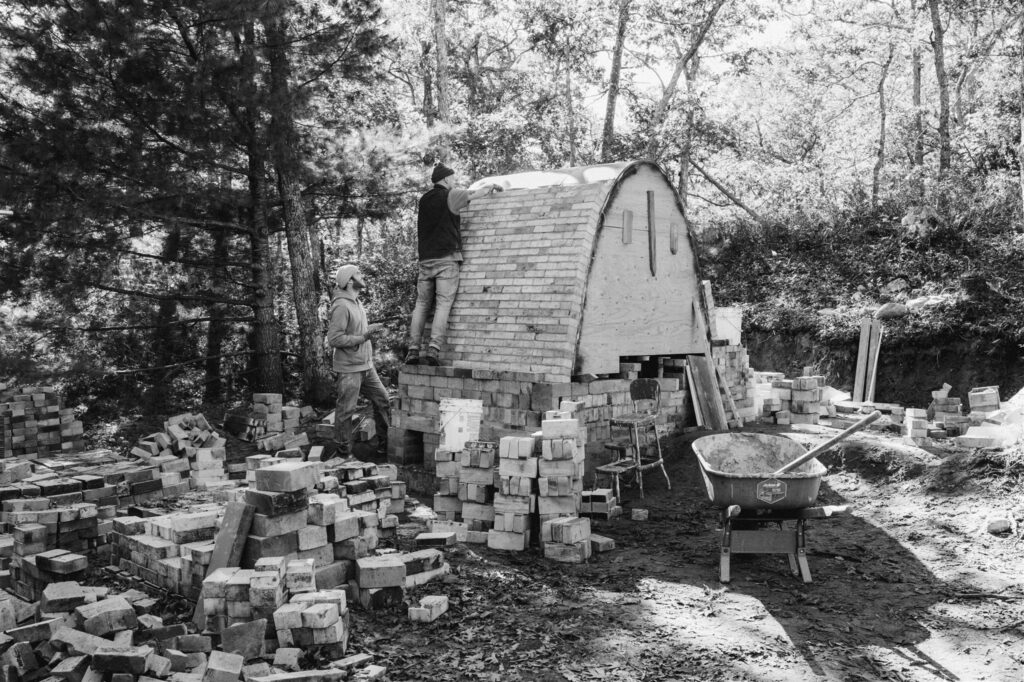 man building wood kiln